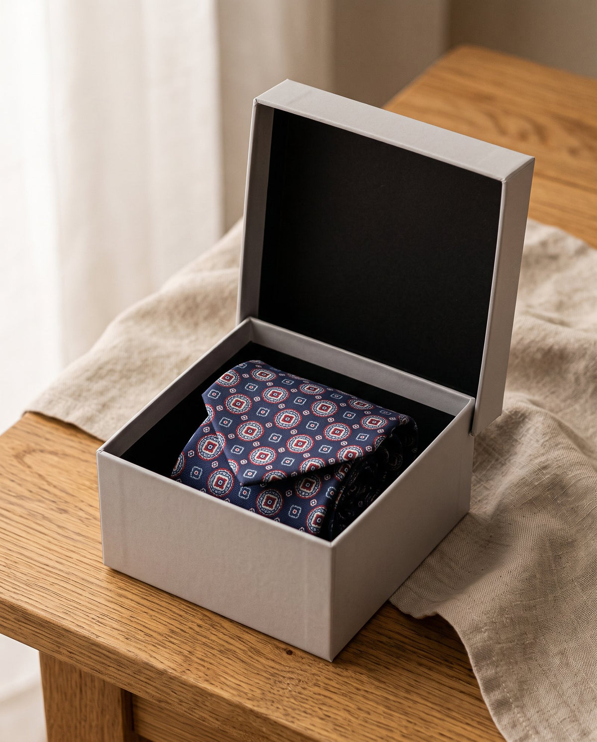 Corbata de Nudo Imperial en su caja de regalo gris con la tapa abierta